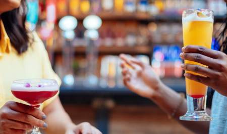 Two friends share cocktails in a bar in Digbeth