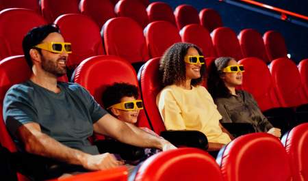 A family of four - Dad, son, mom, daughter sat in a cinema with 4D glasses on
