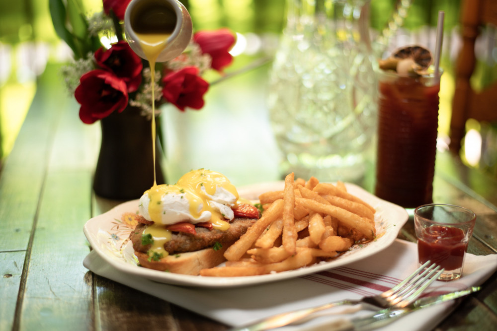 Toast de pain campo, milanesa de bœuf, tomates confites, œufs pochés, sauce hollandaise servi avec frites